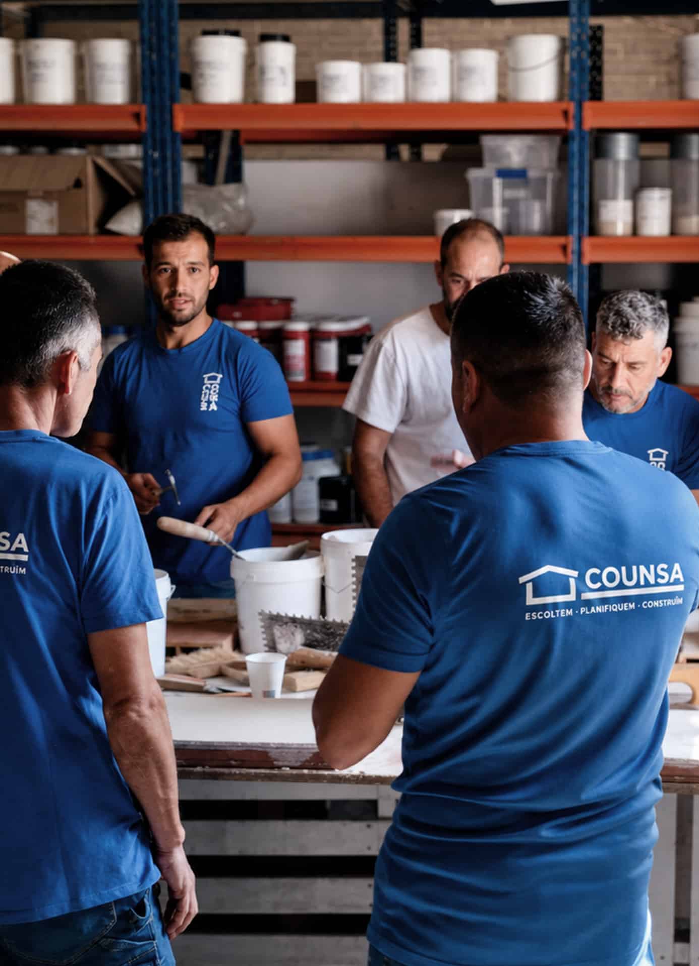Treballadors de Counsa col·laborant en un espai de feina amb material de construcció.